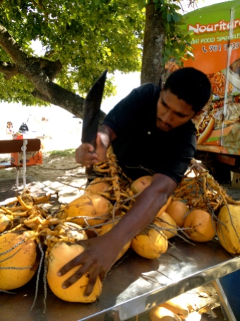 A street vendor selling fresh coconuts in Grand Baie.