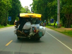 There are three men, a scooter and a couple of large sacks hanging out the back of this van. We got this shot through our windscreen as we followed at highway speeds.